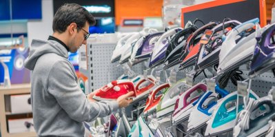 Muž vybírá žehličku v obchodě s elektronikou