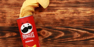 Balíček chipsů Pringles na dřevěném podkladu