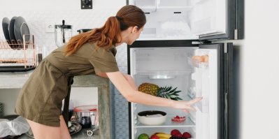 Žena u otevřeného mrazáku a ledničky