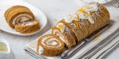 Ukrojená medovníková roláda na bílém talířku