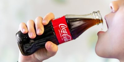 Žena pije Coca-Colu ze sklenice