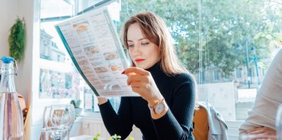Pár v restauraci hledí do jídelního lístku.