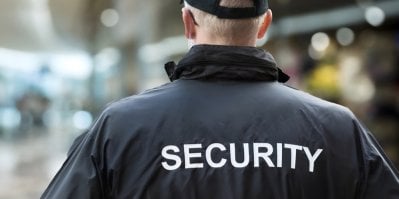 Muž v bundě Security zezadu