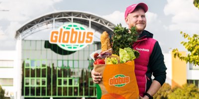 Zaměstnanec foodory drží tašku Globus