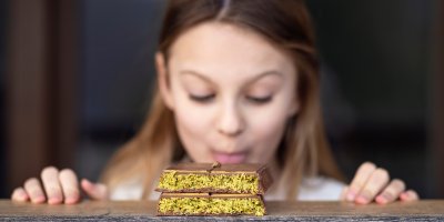 Dívka v pozadí olizuje dubajskou čokoládu