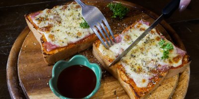 Zapečené pizza toasty na dřevěném prkénku