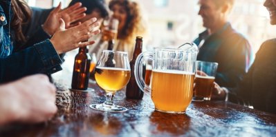 Lidé pijí pivo u stolu v hospodě