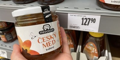Sklenice s medem před cenovkou v obchodě