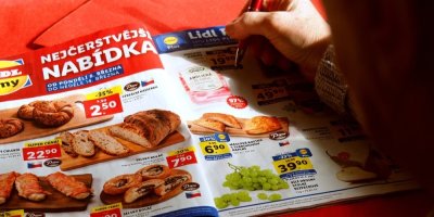 Žena si prohlíží slevový leták řetězce Lidl