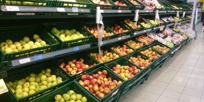 Jablka v plastových přepravkách v supermarketu