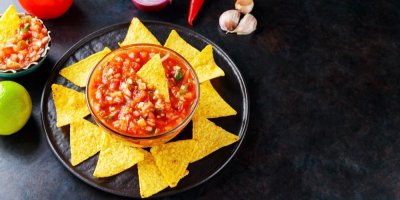 Nachos a rajčatová salsa na černém talíři