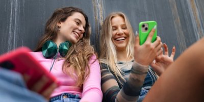 Mladé dívky se dívají do telefonu