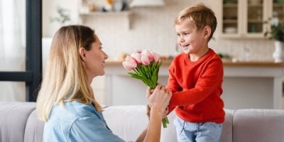Chlapec dává mamince kytici tulipánů