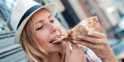 Mladá žena jí pizzu