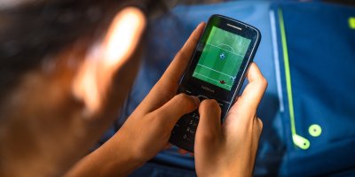 Dítě hraje na mobilu fotbal