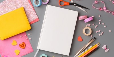 Potřeby pro domácí výrobu obalu na knihu, nůžky, washi páska a dekorativní předměty