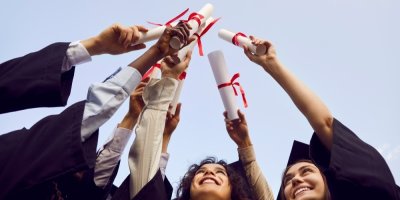 Univerzitní absolventi drží diplomy ve vzduchu