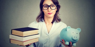 Studentka drží v rukou očebnice a prasátko