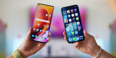Ruce držící dva telefony, srovnání OnePlus 8 Pro vs Apple iPhone 11 Pro
