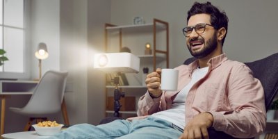 Muž sleduje film na domácím projektoru