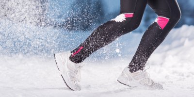 Žena v legínách běhá ve sněhu