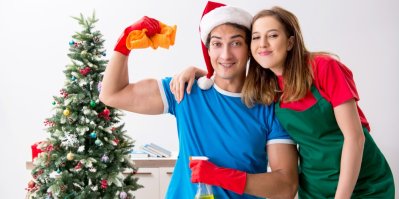 Muž se ženou připraveni na úklid u vánočního stromečku