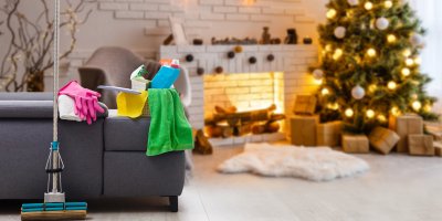 V popředí úklidové prostředky, v pozadí vánoční stromek s dárky