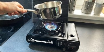 Ruka drží rendlík nad vaříčem