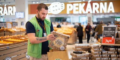 Muž balí koláč do papírové tašky Globus