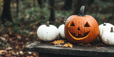 Dvě Halloweenské dýně s vydlabaným obličejem a svíčkou v osvětelném parku