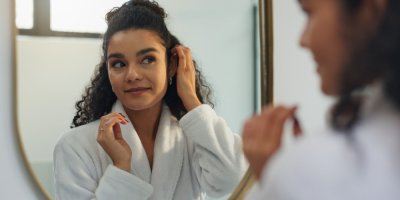 Mladá žena se dívá do zrcadla