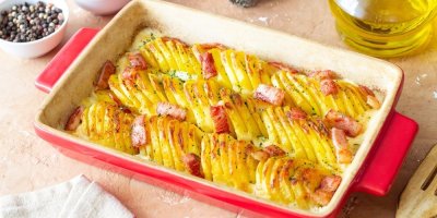 Zapečené brambory se šunkou, sýrem a smetanou: Recept z jednoho pekáče, který ušetří čas i nádobí