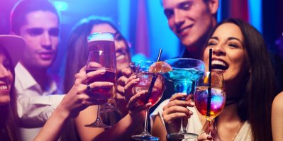 Skupina přátel si připíjí skleničkami s alkoholem
