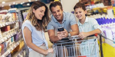 Veselá mladá rodina v supermarketu