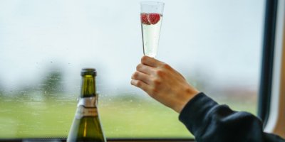 Žena pije prosecco ve vlaku