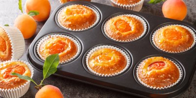 Půlka meruňky do každého košíčku. Tyhle jogurtové muffiny jsou hotové bez šlehání i kynutí