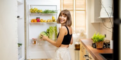 Žena dává zeleninu do lednice