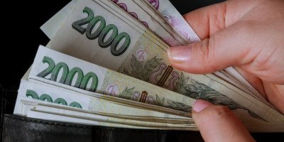 Ruce vytahující české bankovky z peněženky