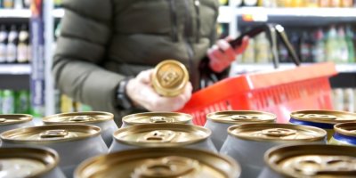 Muž vybírá v supermarketu pivo v plechovce