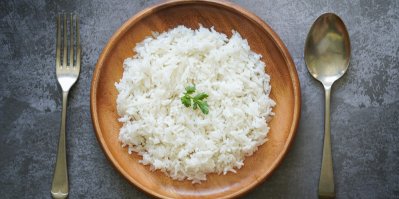 Uvařená rýži na talíři s vidličkou a lžičkou