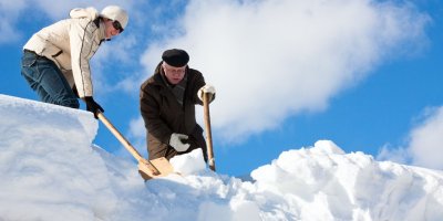 Žena s mužem odhazují hrablem sníh