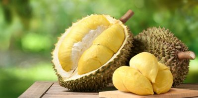 Vyloupané plody durianu a durian vcelku na stole