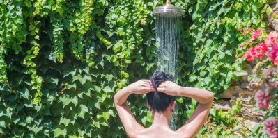 Žena se sprchuje na zahradě
