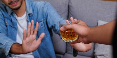 Muži je nabízena sklenice alkoholu, on ji gestem odmítá