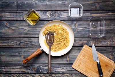 Osmažená cibulka na pánvi, vedle olej a prkénko.