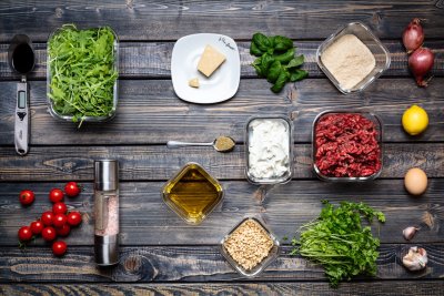 Všechny ingredience na karbanátky položeny na dřevěném stole.