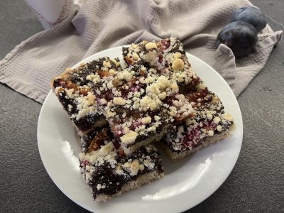 Švestkový koláč s mákem a drobenkou nakrájený na talíři