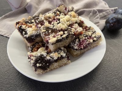 Švestkový koláč s mákem a drobenkou nakrájený na talíři