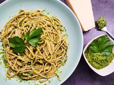 Petrželové pesto v bílé misce vedle pesto zamíchané v těstovinách