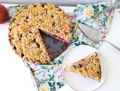 Nakrojený malinový koláč a kus koláče na bílém talířku